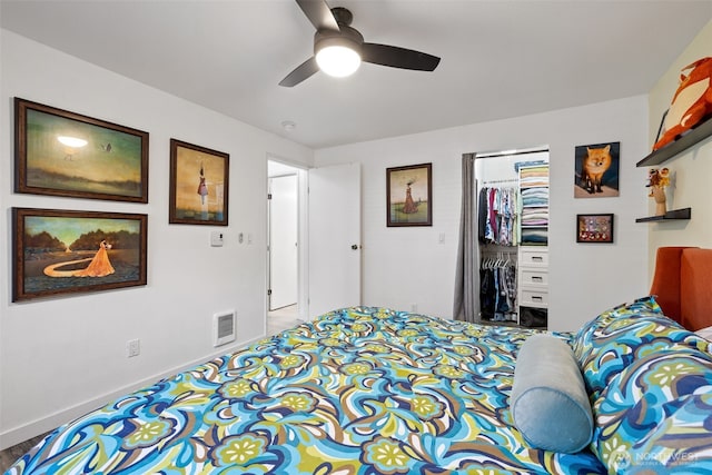 bedroom featuring a ceiling fan, visible vents, baseboards, a closet, and a walk in closet