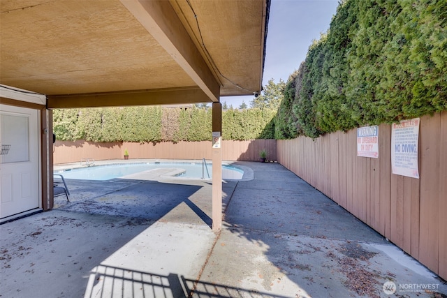 view of patio with a fenced backyard and a community pool