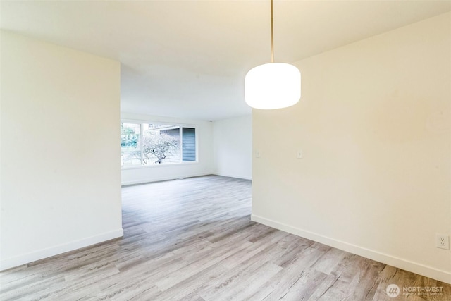 unfurnished room with light wood-style floors and baseboards