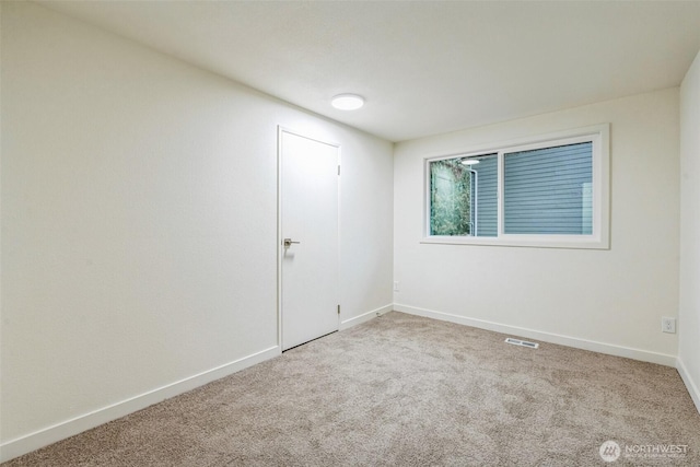 carpeted spare room with baseboards and visible vents