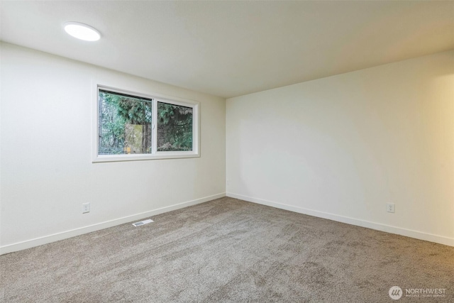 carpeted empty room featuring visible vents and baseboards