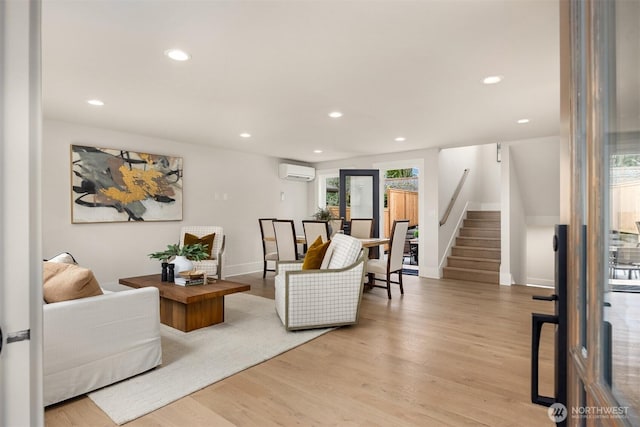 living room with a wall mounted air conditioner, wood finished floors, recessed lighting, stairway, and baseboards