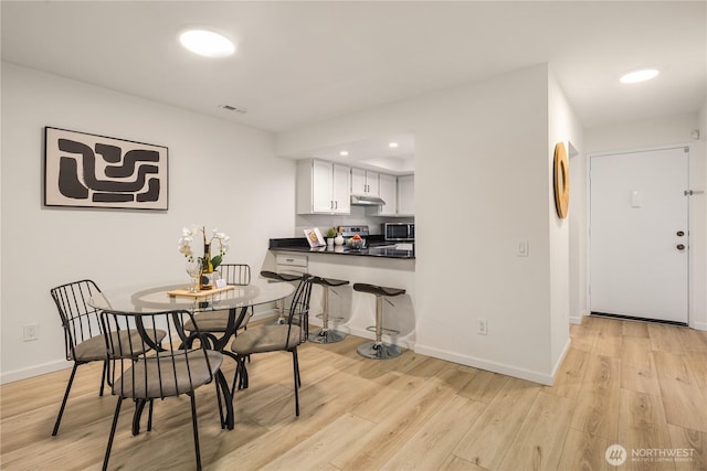 dining room featuring light wood finished floors, visible vents, recessed lighting, and baseboards