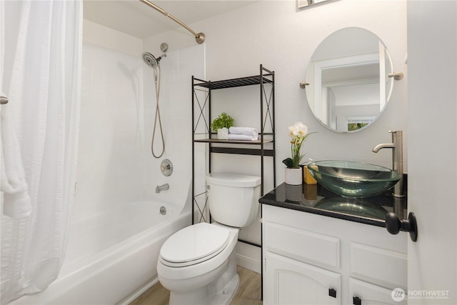 bathroom featuring wood finished floors, toilet, vanity, and shower / bath combo