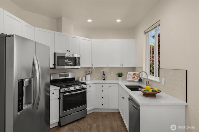 kitchen with white cabinetry, tasteful backsplash, appliances with stainless steel finishes, and a sink