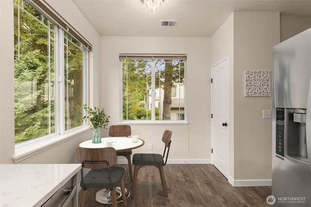 dining area featuring dark wood-style floors, a healthy amount of sunlight, and visible vents