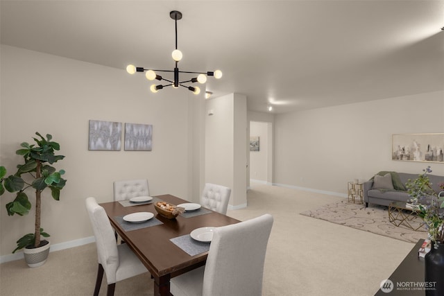 carpeted dining space featuring a notable chandelier and baseboards