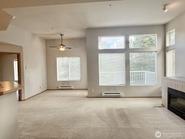 unfurnished living room with a baseboard radiator, light carpet, baseboards, and a tiled fireplace