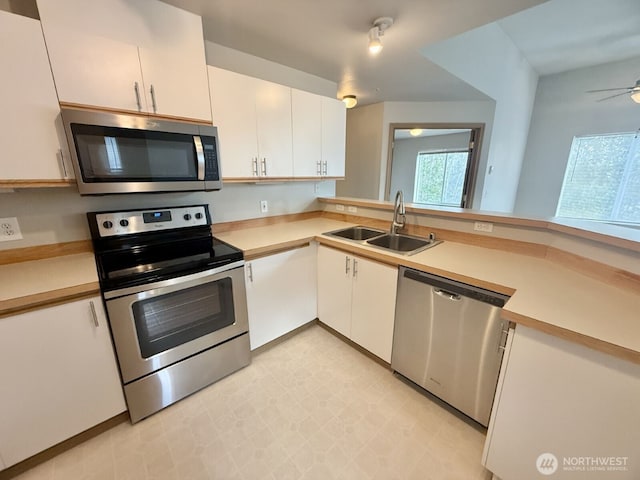 kitchen featuring a sink, light floors, appliances with stainless steel finishes, and light countertops