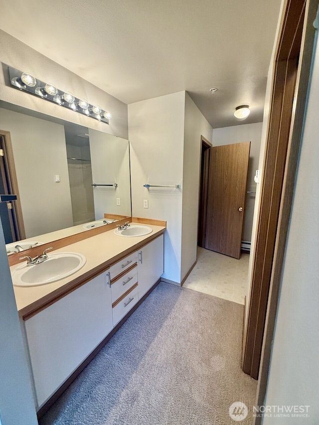 bathroom with double vanity, carpet, and a sink