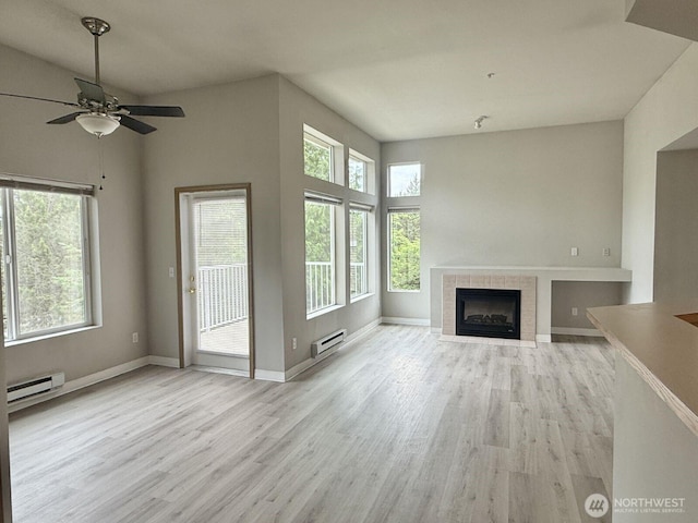 22212 42nd Ave S Unit 204, Kent, WA 98032 - unfurnished living room with wood finished floors, plenty of natural light, and a tiled fireplace