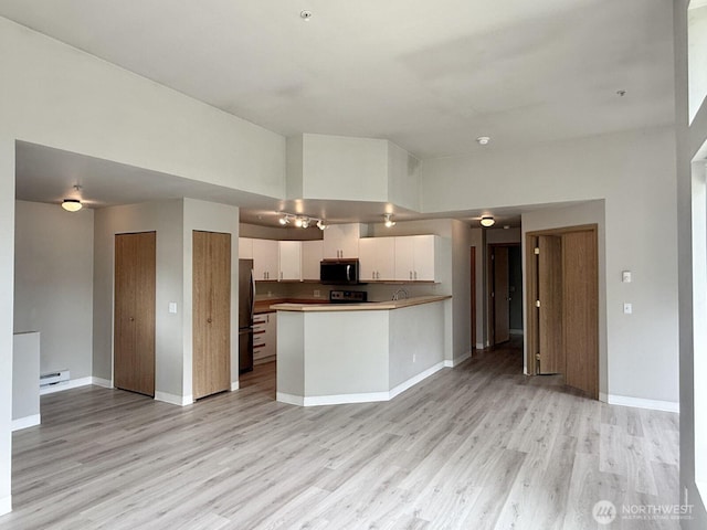 22212 42nd Ave S Unit 204, Kent, WA 98032 - kitchen with freestanding refrigerator, light wood finished floors, white cabinetry, and open floor plan