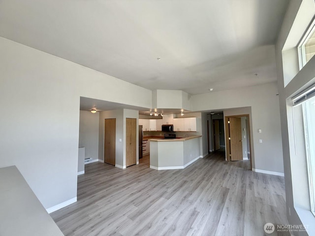 22212 42nd Ave S Unit 204, Kent, WA 98032 - kitchen featuring open floor plan, black microwave, white cabinets, and light wood-type flooring