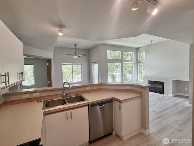 22212 42nd Ave S Unit 204, Kent, WA 98032 - kitchen with stainless steel dishwasher, open floor plan, a ceiling fan, a fireplace, and light countertops