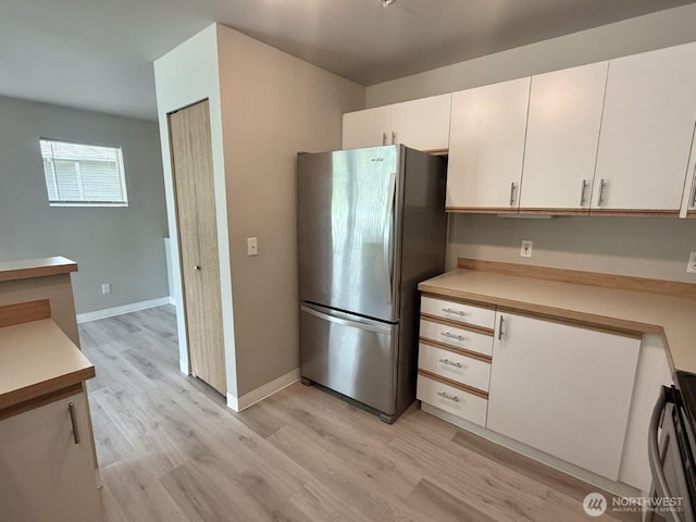 22212 42nd Ave S Unit 204, Kent, WA 98032 - kitchen featuring freestanding refrigerator, light wood-style floors, light countertops, range, and white cabinetry