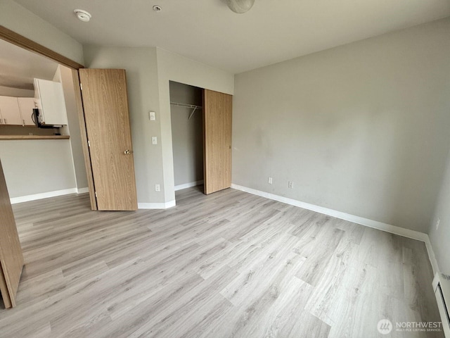 22212 42nd Ave S Unit 204, Kent, WA 98032 - unfurnished bedroom with a closet, light wood-style flooring, and baseboard heating