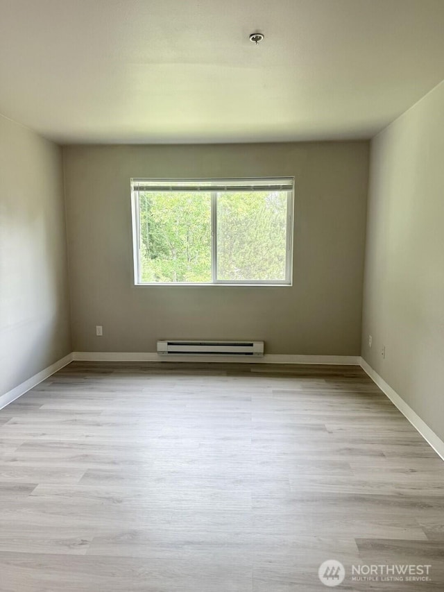22212 42nd Ave S Unit 204, Kent, WA 98032 - empty room with a baseboard heating unit, light wood-style flooring, and a pendent fire sprinkler