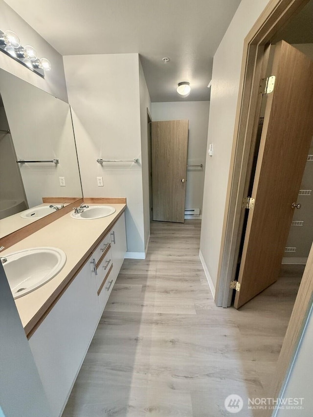22212 42nd Ave S Unit 204, Kent, WA 98032 - bathroom featuring double vanity, wood finished floors, and baseboard heating
