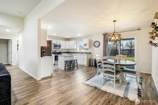 dining space with recessed lighting, a healthy amount of sunlight, baseboards, and light wood finished floors