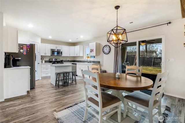 dining room featuring a ceiling fan, wood finished floors, visible vents, baseboards, and recessed lighting