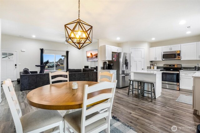 dining area featuring recessed lighting, visible vents, an inviting chandelier, and wood finished floors