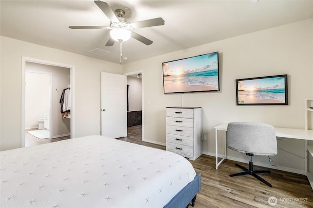 bedroom with a ceiling fan, wood finished floors, visible vents, baseboards, and ensuite bath