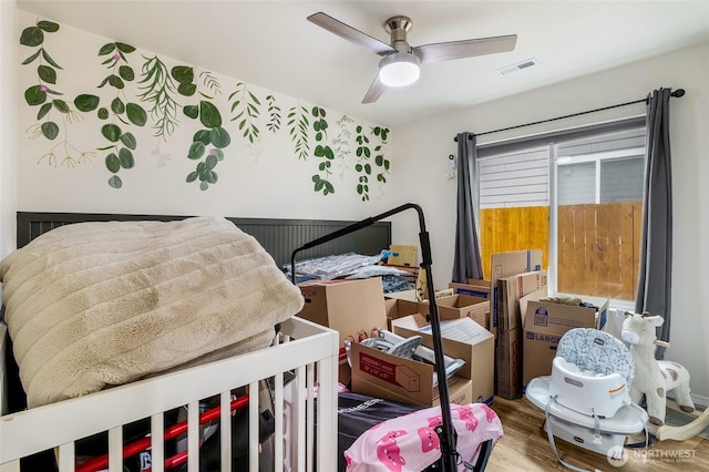 bedroom with visible vents, wood finished floors, and a ceiling fan