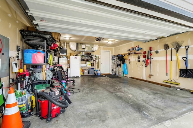 garage with a garage door opener and freestanding refrigerator