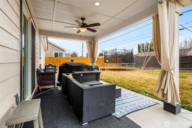 view of patio with a fenced backyard, ceiling fan, an outdoor hangout area, and a trampoline