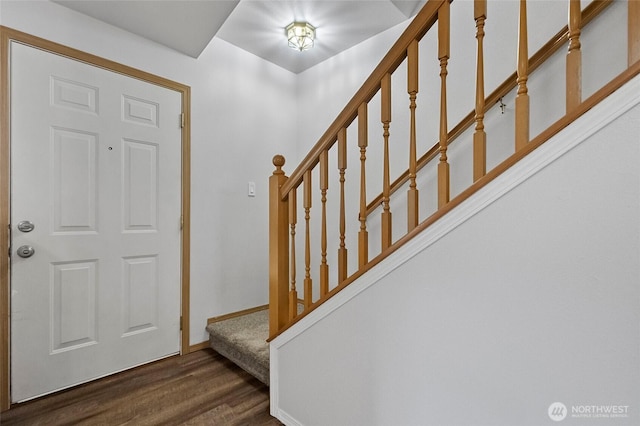 foyer entrance with stairway, baseboards, and wood finished floors