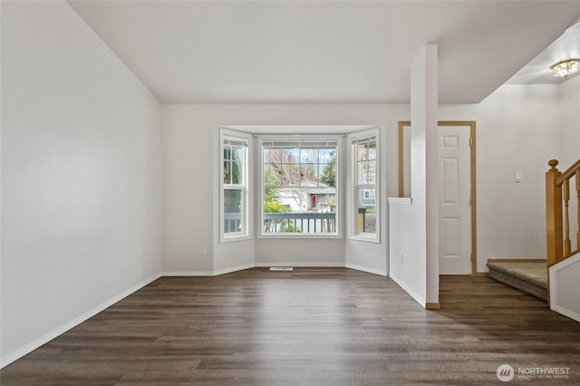 foyer with baseboards, dark wood-style floors, and stairs