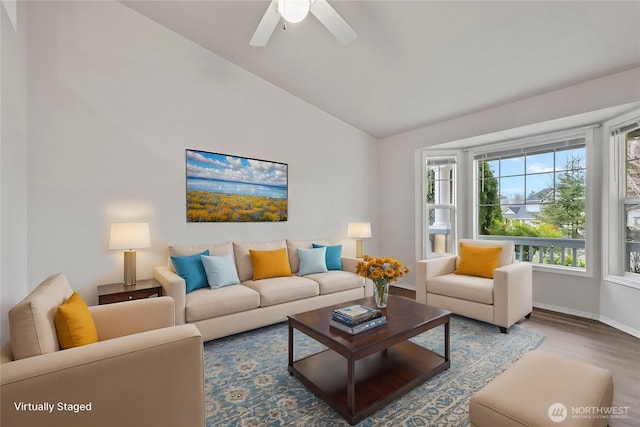 living area featuring ceiling fan, baseboards, lofted ceiling, and wood finished floors