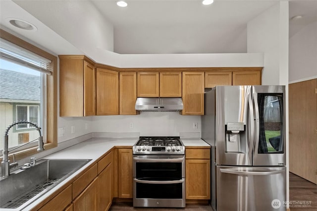 kitchen featuring under cabinet range hood, recessed lighting, brown cabinets, stainless steel appliances, and a sink