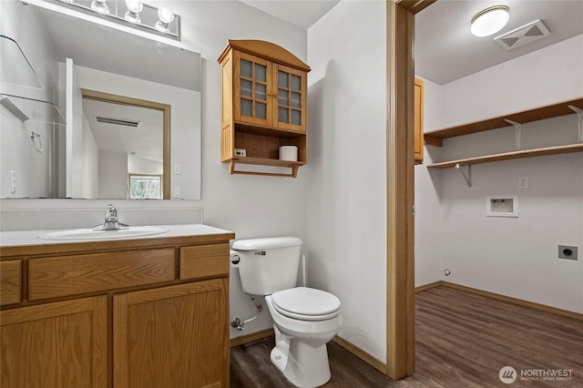 bathroom featuring visible vents, toilet, wood finished floors, baseboards, and vanity