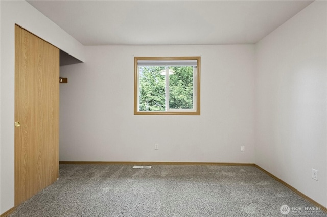 carpeted spare room with baseboards and visible vents