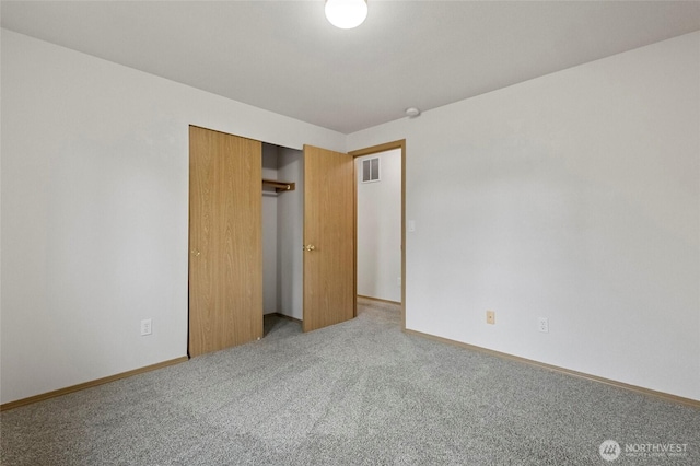 unfurnished bedroom with a closet, visible vents, carpet flooring, and baseboards