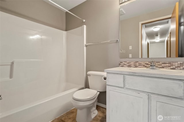 bathroom featuring decorative backsplash, vanity, toilet, and bathing tub / shower combination