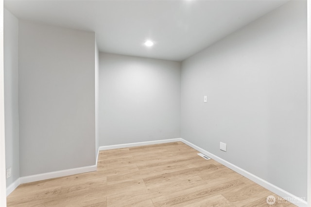 unfurnished room with light wood-style flooring, visible vents, and baseboards