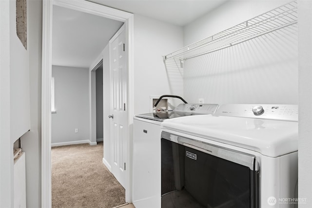 laundry area featuring light carpet, laundry area, washer and dryer, and baseboards