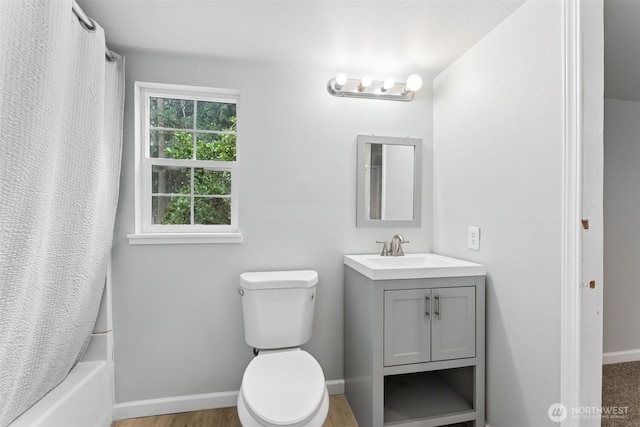 full bathroom with shower / bath combo with shower curtain, toilet, vanity, and baseboards