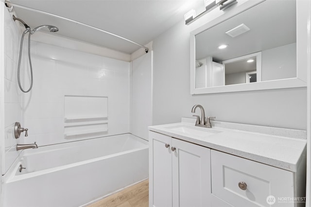 bathroom with visible vents, washtub / shower combination, vanity, and wood finished floors