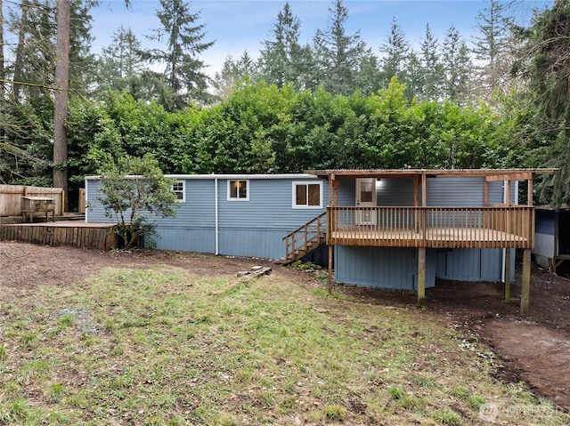 back of property featuring a wooden deck, stairs, and fence