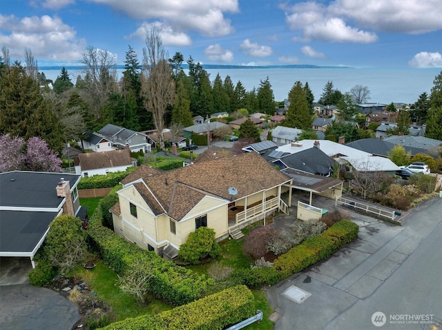 drone / aerial view featuring a residential view and a water view