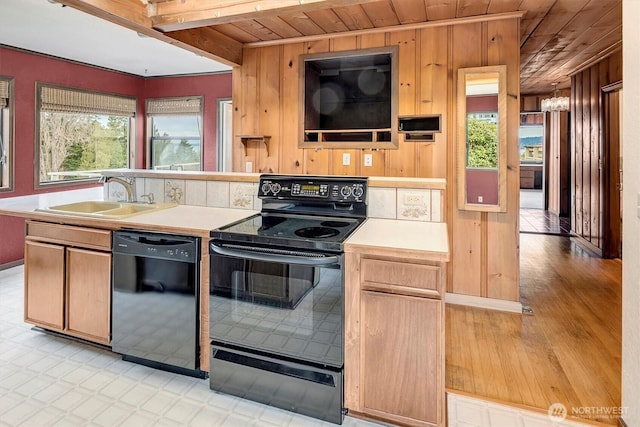 kitchen with wooden ceiling, black appliances, light countertops, and a sink