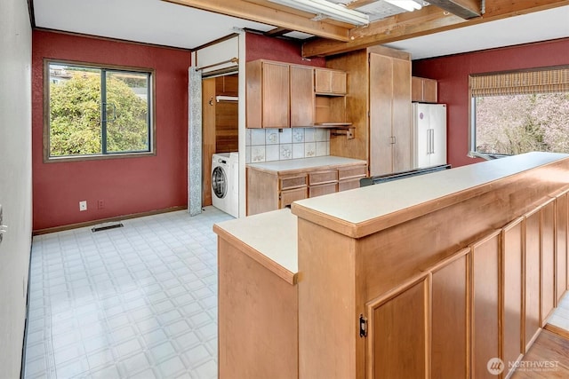 kitchen featuring light floors, visible vents, washer / dryer, light countertops, and fridge