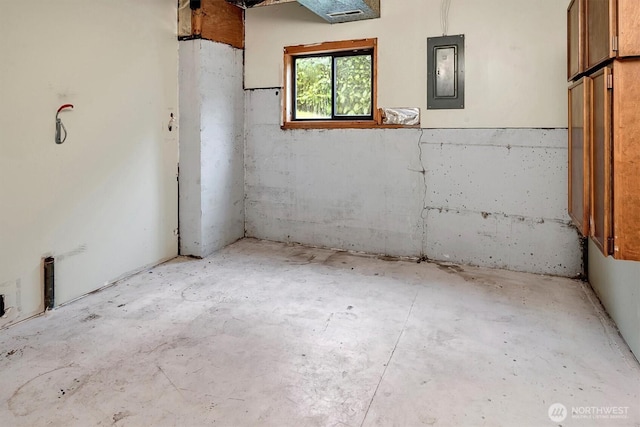 interior space with electric panel and concrete flooring