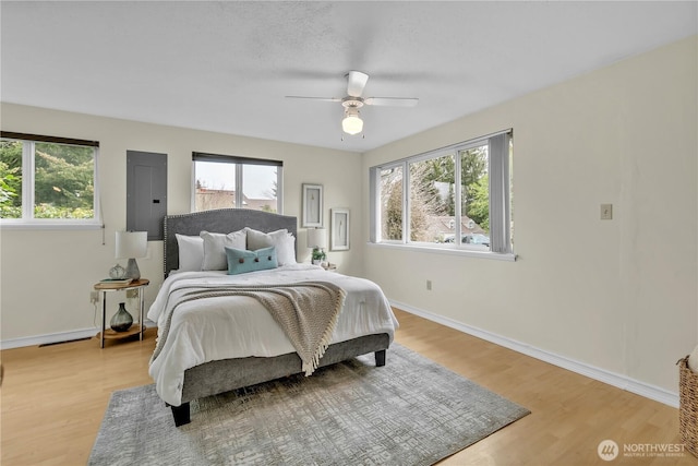 bedroom with ceiling fan, light wood-type flooring, and baseboards