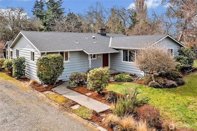 ranch-style house with a chimney, a front lawn, and roof with shingles