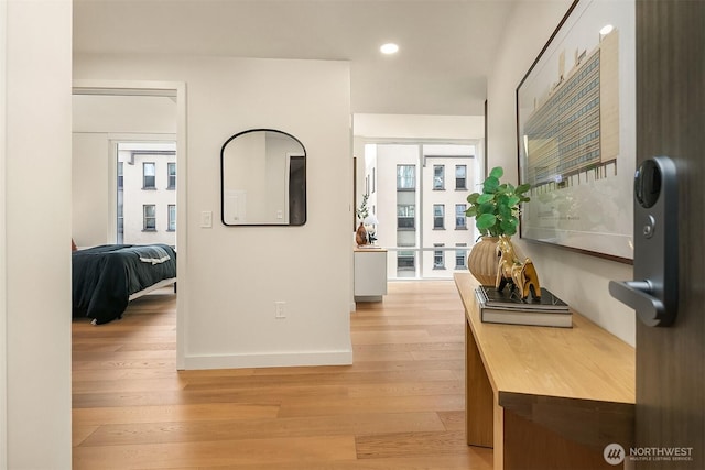 corridor featuring recessed lighting, baseboards, and light wood finished floors