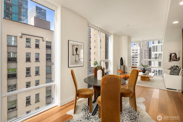 dining area featuring floor to ceiling windows, wood finished floors, and baseboards